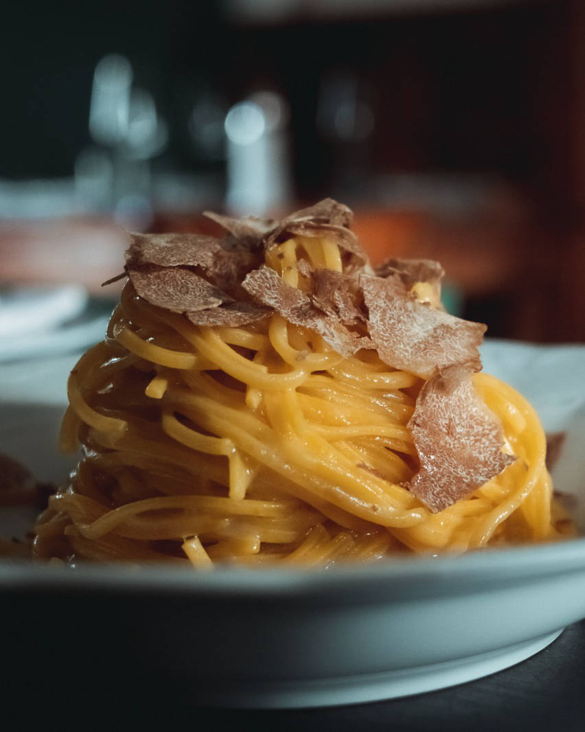 Un piatto di pasta fresca coperto di una grattugiata di tartufo bianco